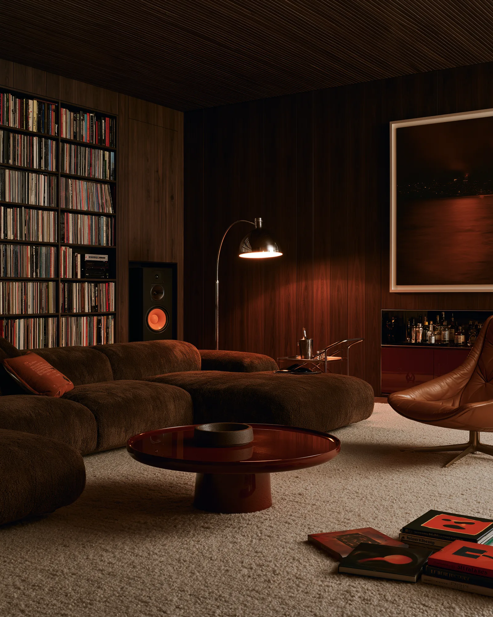 Walnut-panelled listening room with deep seating, a record wall and a lacquered table