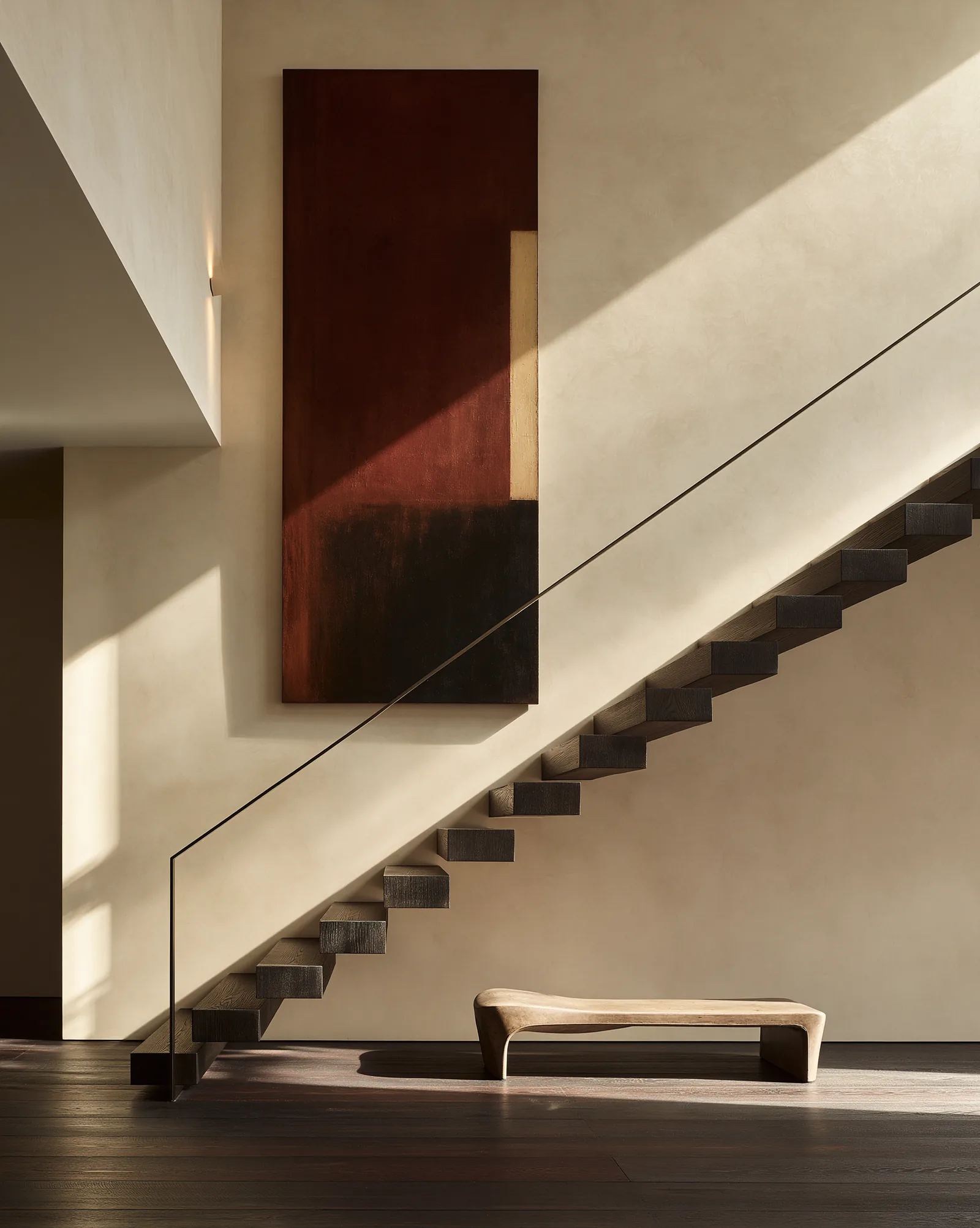 Cantilevered dark oak staircase against plaster with a slim steel handrail