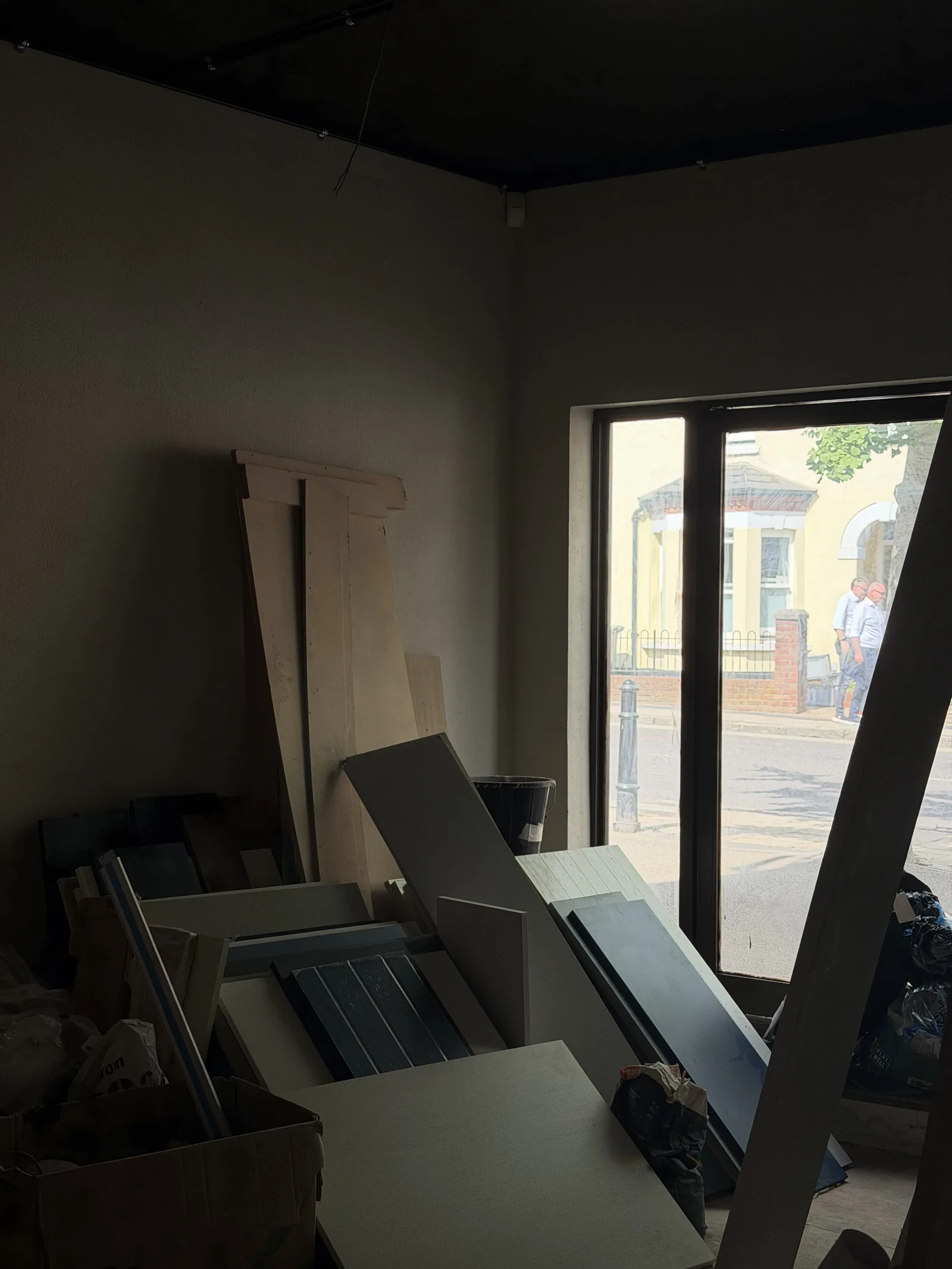 Victoria Street on site — looking towards the shopfront window, with joinery panels and materials stored inside